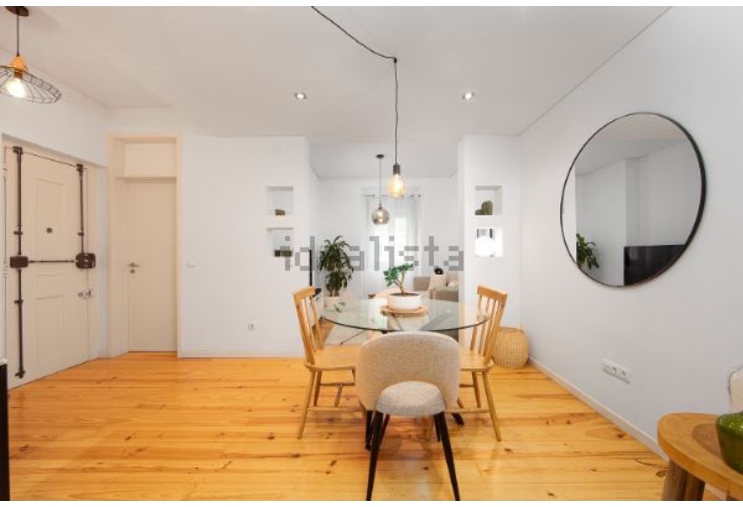 Dining table under pendant lights with a large round mirror on the wall